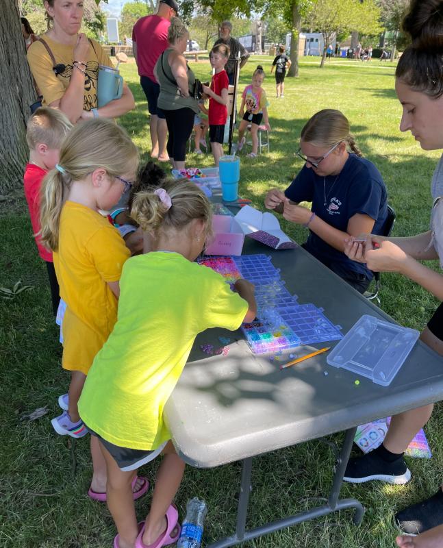FFA Member, Bri Dulin teaches kids how to make bracelets at Party in the Park